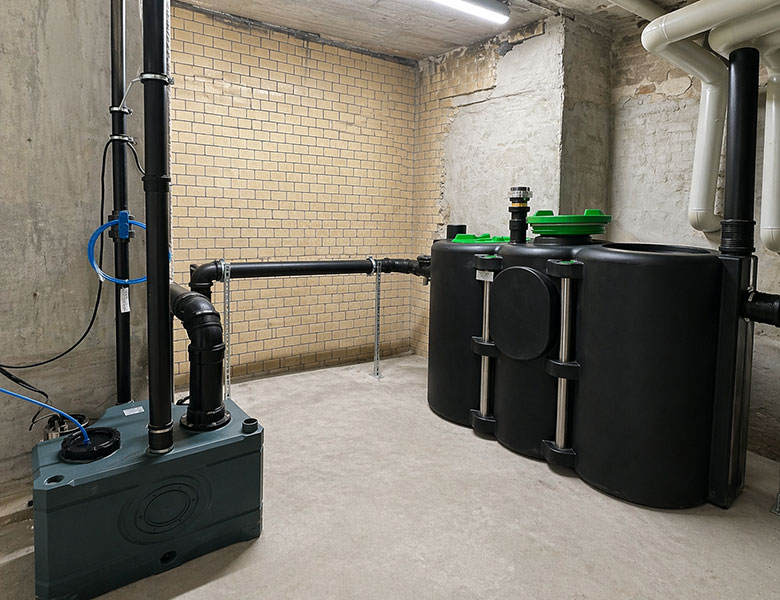 Fettabscheider mit Hebeanlage und Abwasserleitungen in einem Kellerraum in Berlin Neukölln